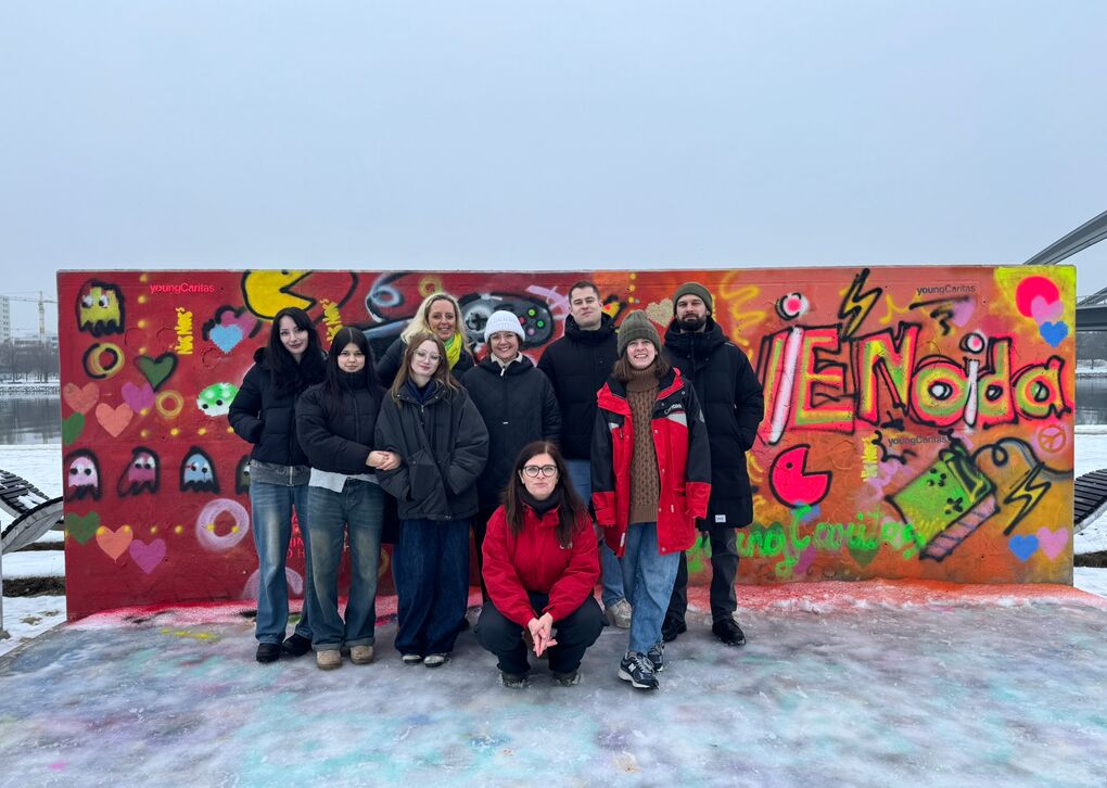 Freiwillige aus dem actionPool stehen vor Graffiti Wand mit zwei Influencer