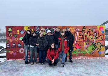 Freiwillige aus dem actionPool stehen vor Graffiti Wand mit zwei Influencer