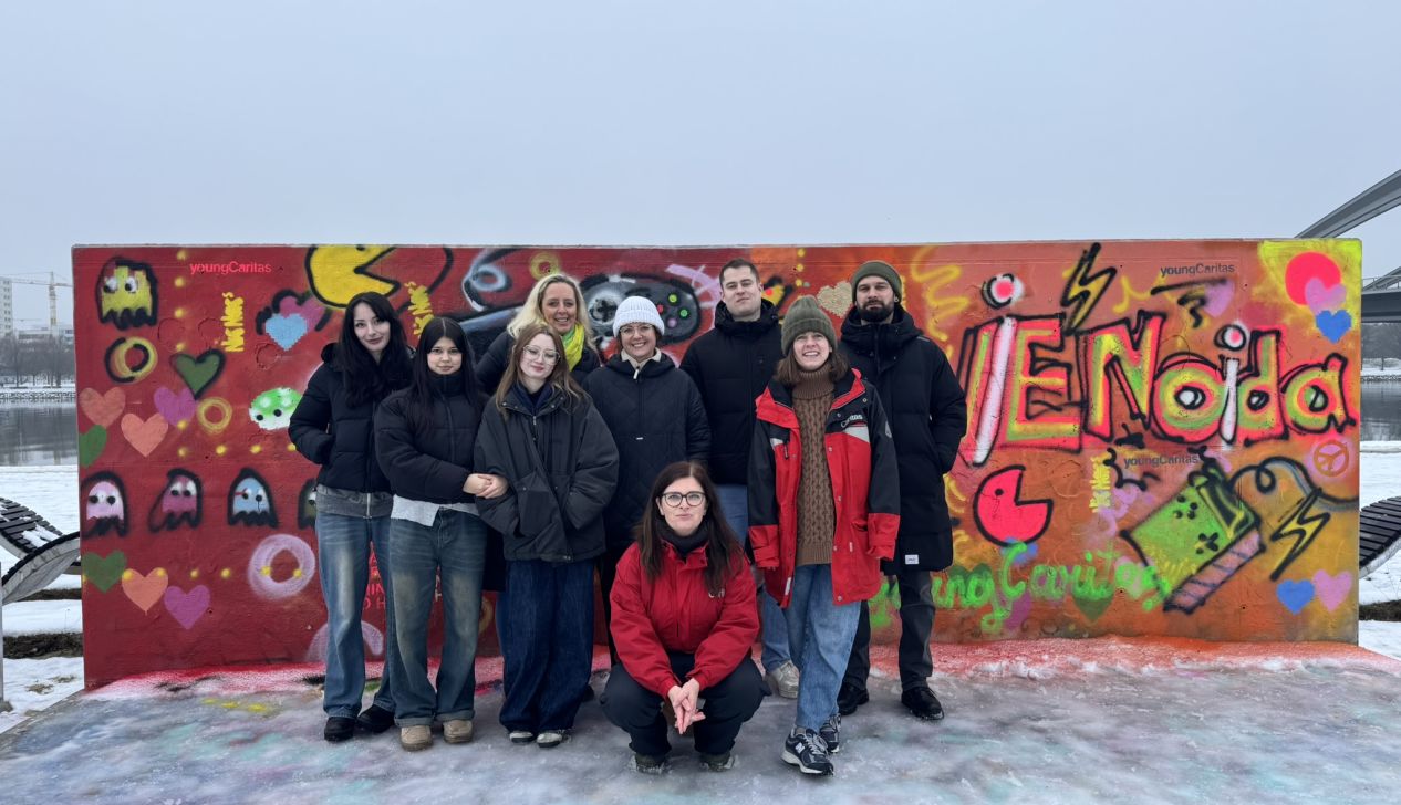 Freiwillige aus dem actionPool stehen vor Graffiti Wand mit zwei Influencer